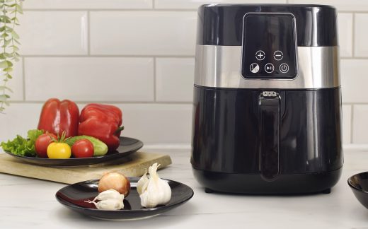 Black oil-free fryer in the kitchen. Cooking in an air fryer without oil. Healthy food preparation.